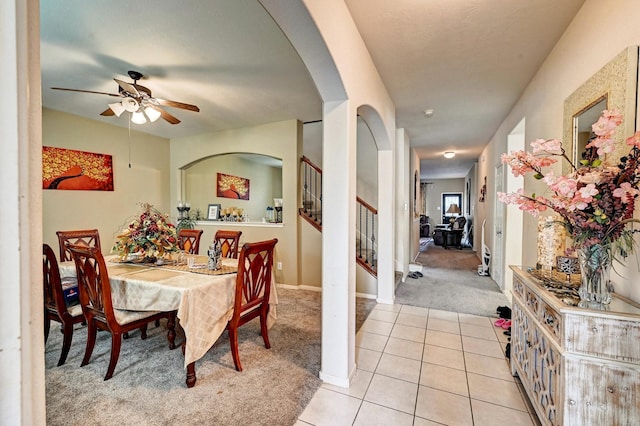 carpeted dining space with ceiling fan