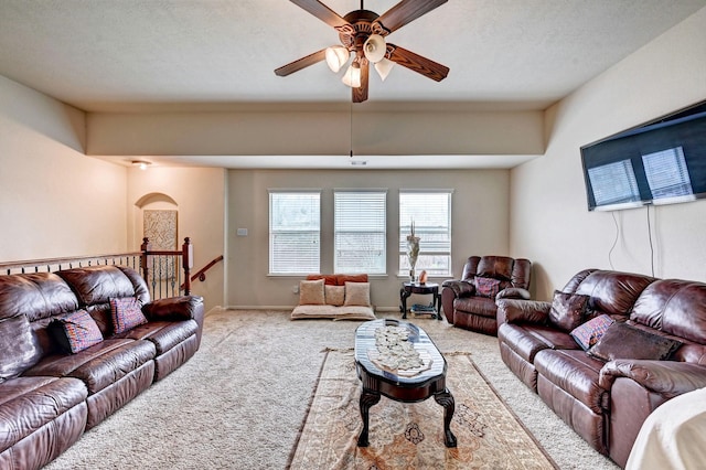 living room featuring ceiling fan, light colored carpet, and a textured ceiling