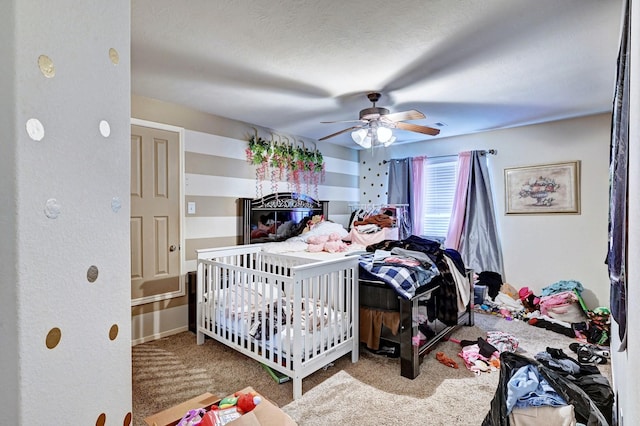 carpeted bedroom with a textured ceiling and ceiling fan