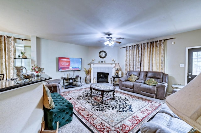 living room featuring ceiling fan and a fireplace