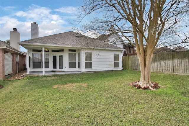 back of property with french doors, a patio area, and a lawn