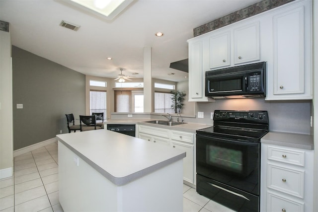 kitchen with sink, light tile patterned floors, white cabinetry, black appliances, and a kitchen island