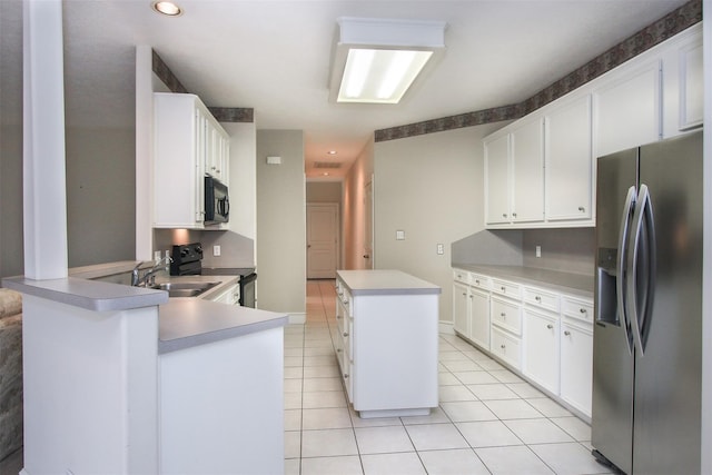 kitchen with light tile patterned floors, sink, a center island, black appliances, and white cabinets