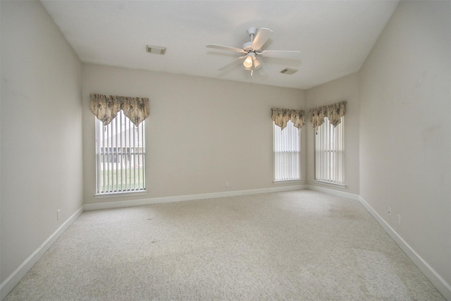 unfurnished room featuring a healthy amount of sunlight, light carpet, and ceiling fan