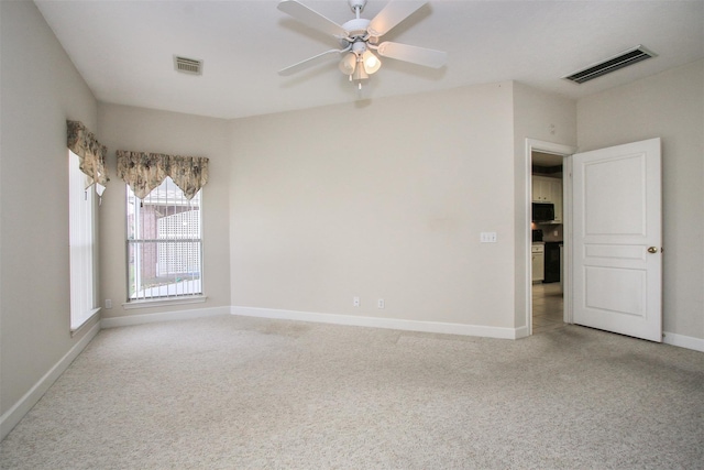 carpeted spare room featuring ceiling fan