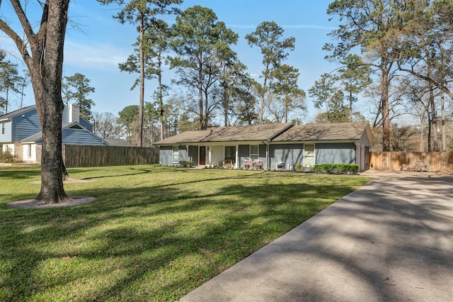 view of front of house featuring fence and a front lawn