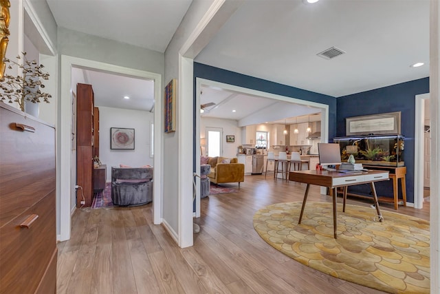 office area with light wood-type flooring, beam ceiling, visible vents, and baseboards