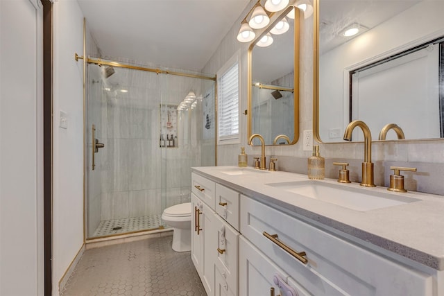 bathroom with toilet, a stall shower, and a sink