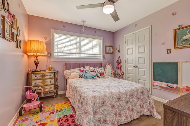 bedroom with a closet, wood finished floors, and baseboards