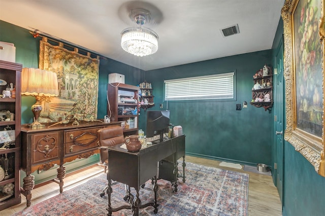 office area featuring wood finished floors, visible vents, baseboards, and an inviting chandelier