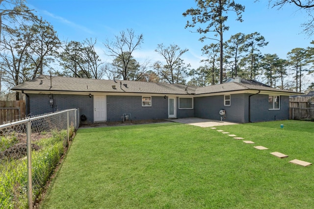 rear view of house with a patio area, a fenced backyard, a lawn, and brick siding