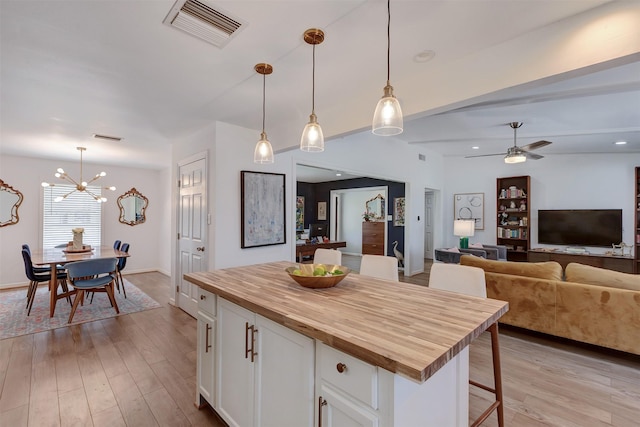 kitchen featuring butcher block counters, light wood-style flooring, visible vents, and white cabinets