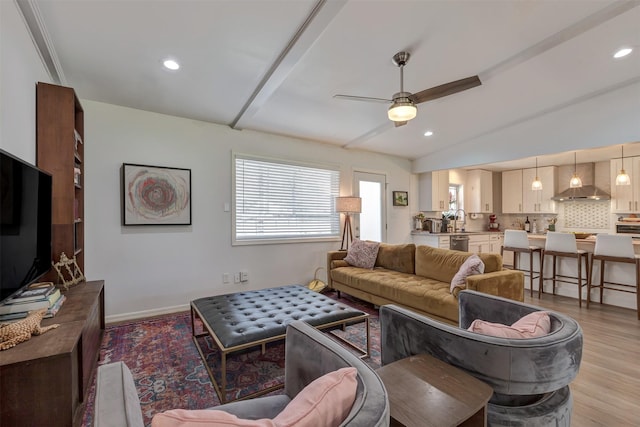 living room featuring light wood finished floors, baseboards, a ceiling fan, lofted ceiling with beams, and recessed lighting