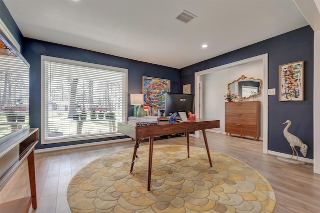 office area with visible vents, light wood-style flooring, and baseboards