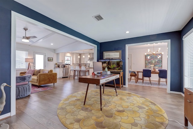 home office with light wood-style floors, visible vents, vaulted ceiling with beams, and ceiling fan with notable chandelier