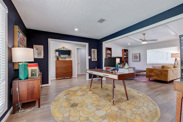 office area with a ceiling fan, beam ceiling, visible vents, and wood finished floors