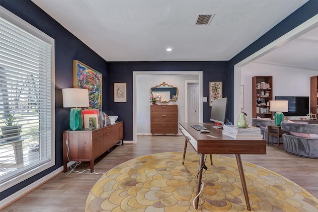 office space featuring light wood-style flooring, visible vents, and baseboards