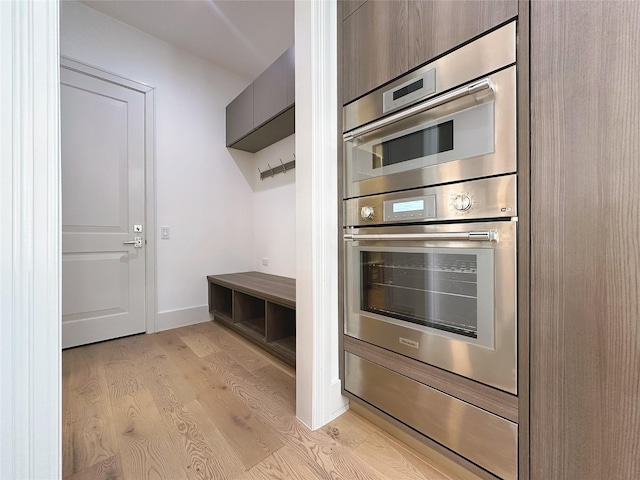 kitchen featuring double oven and light wood-type flooring