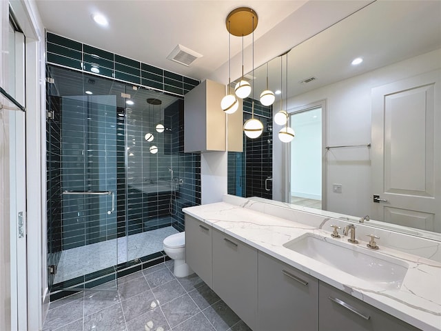 bathroom featuring vanity, toilet, and a shower with shower door