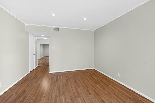 empty room with crown molding and hardwood / wood-style floors