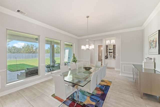 tiled dining space featuring an inviting chandelier and ornamental molding