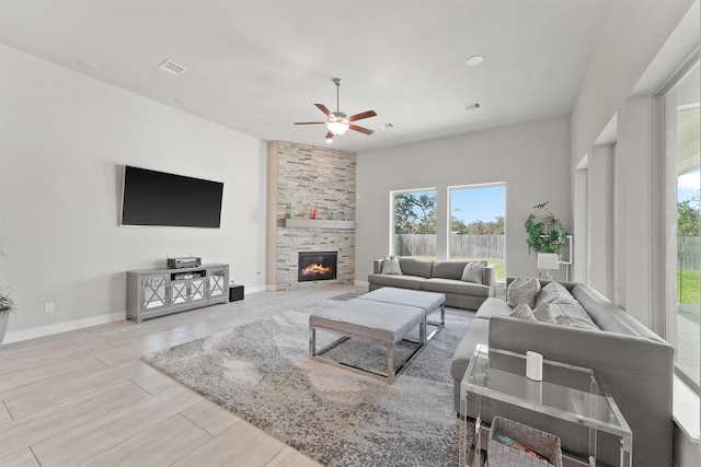 living room featuring ceiling fan and a fireplace