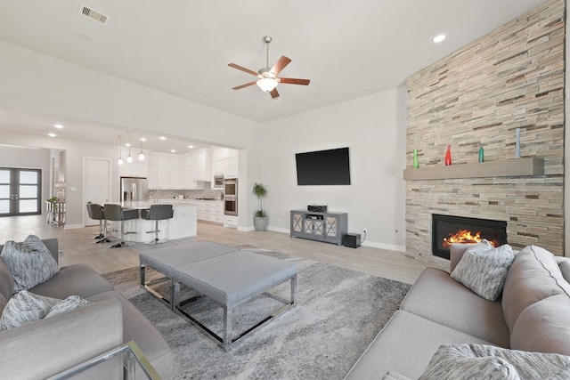 living room with a fireplace and ceiling fan