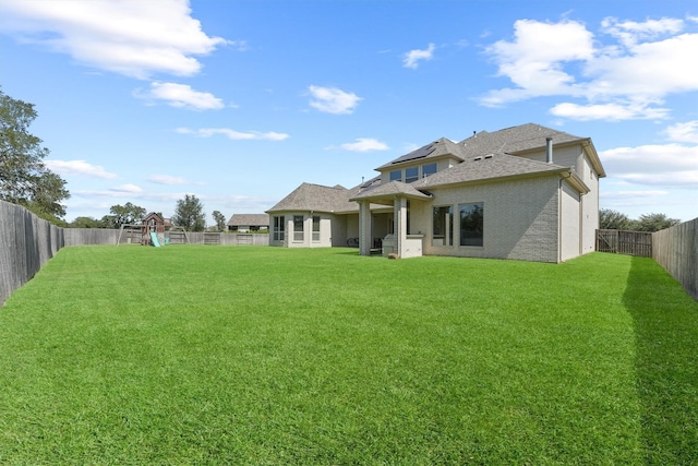 back of house with a playground and a lawn