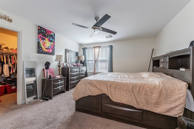 bedroom with carpet flooring, a spacious closet, ceiling fan, and a closet