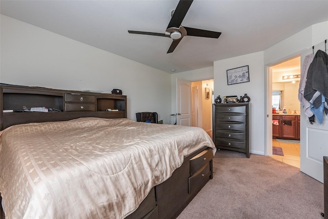 bedroom featuring connected bathroom, light colored carpet, and ceiling fan