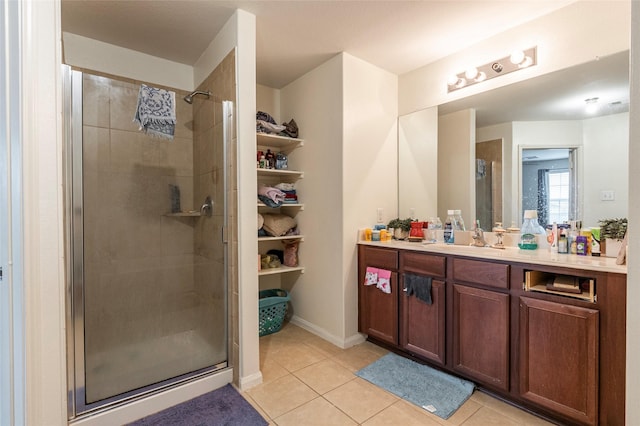 bathroom featuring a shower with door, vanity, and tile patterned floors