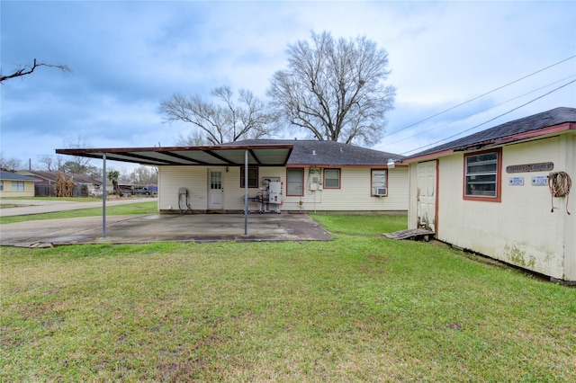 back of property featuring a carport and a lawn