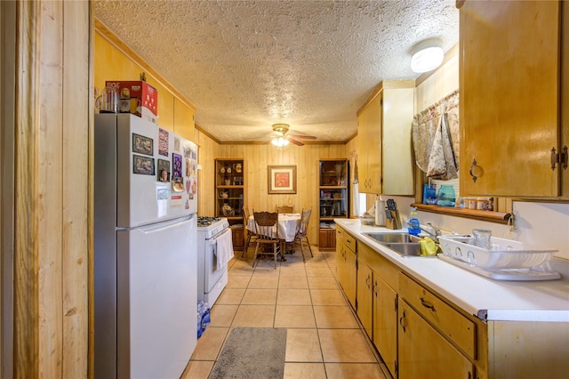 kitchen featuring light tile patterned flooring, sink, white appliances, crown molding, and a textured ceiling