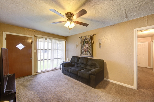 carpeted living room featuring ceiling fan and a textured ceiling