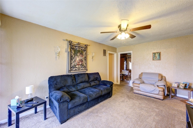 living room featuring ceiling fan, carpet, and a textured ceiling