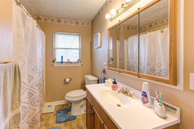 bathroom with vanity, toilet, and a textured ceiling