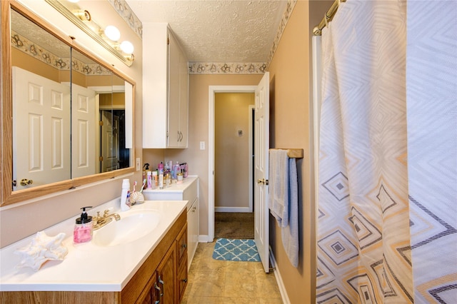 bathroom featuring vanity, tile patterned floors, and a textured ceiling