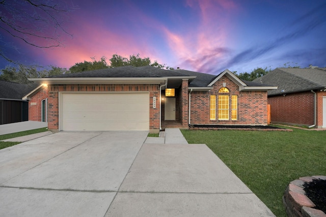 single story home featuring a garage and a lawn