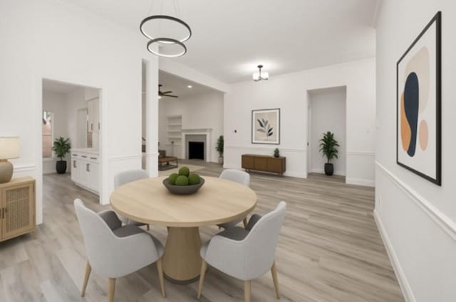 14339 Arborcrest St, Houston, TX 77062 - dining area featuring light wood-style flooring, a fireplace, ceiling fan, and baseboards