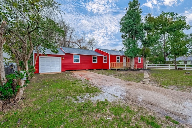 ranch-style home with a wooden deck, a garage, and a front lawn