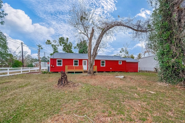 rear view of property featuring a wooden deck and a yard