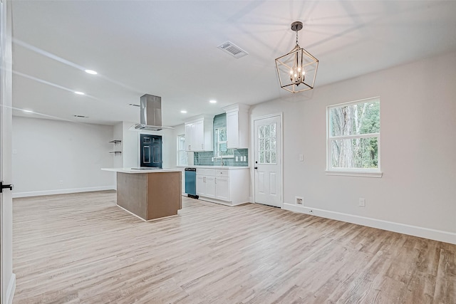 kitchen featuring extractor fan, decorative light fixtures, white cabinetry, decorative backsplash, and a center island