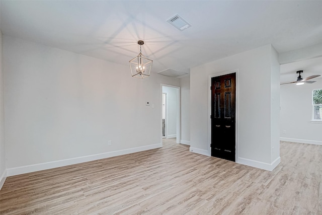 unfurnished room featuring a notable chandelier and light hardwood / wood-style flooring