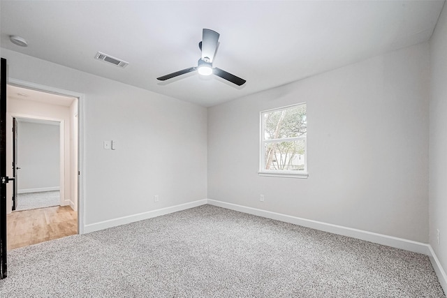 empty room featuring ceiling fan and carpet