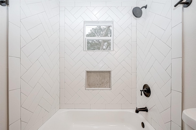 bathroom with tiled shower / bath and toilet