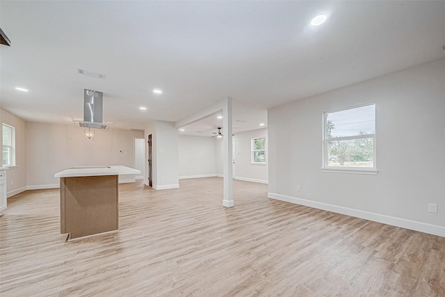 basement with light hardwood / wood-style floors and ceiling fan