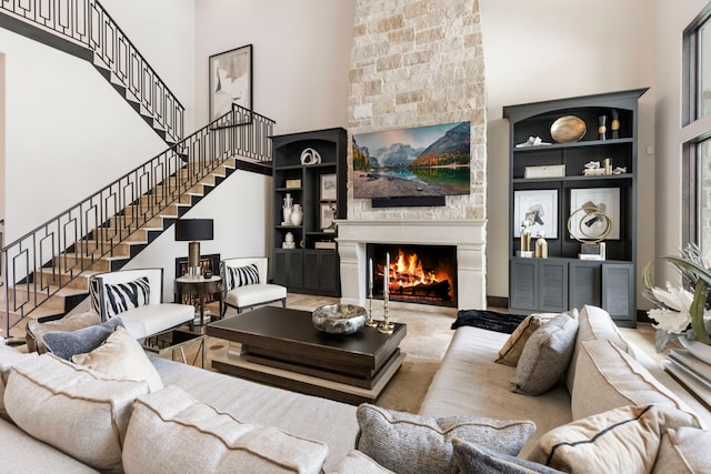 living room with a fireplace and a towering ceiling