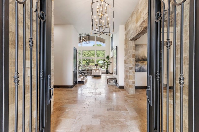 foyer entrance featuring a chandelier and a towering ceiling