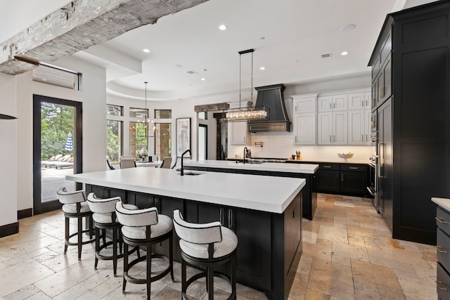 kitchen featuring pendant lighting, custom range hood, a kitchen breakfast bar, a large island, and tasteful backsplash