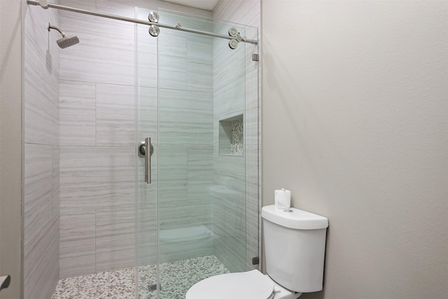 bathroom featuring toilet and an enclosed shower
